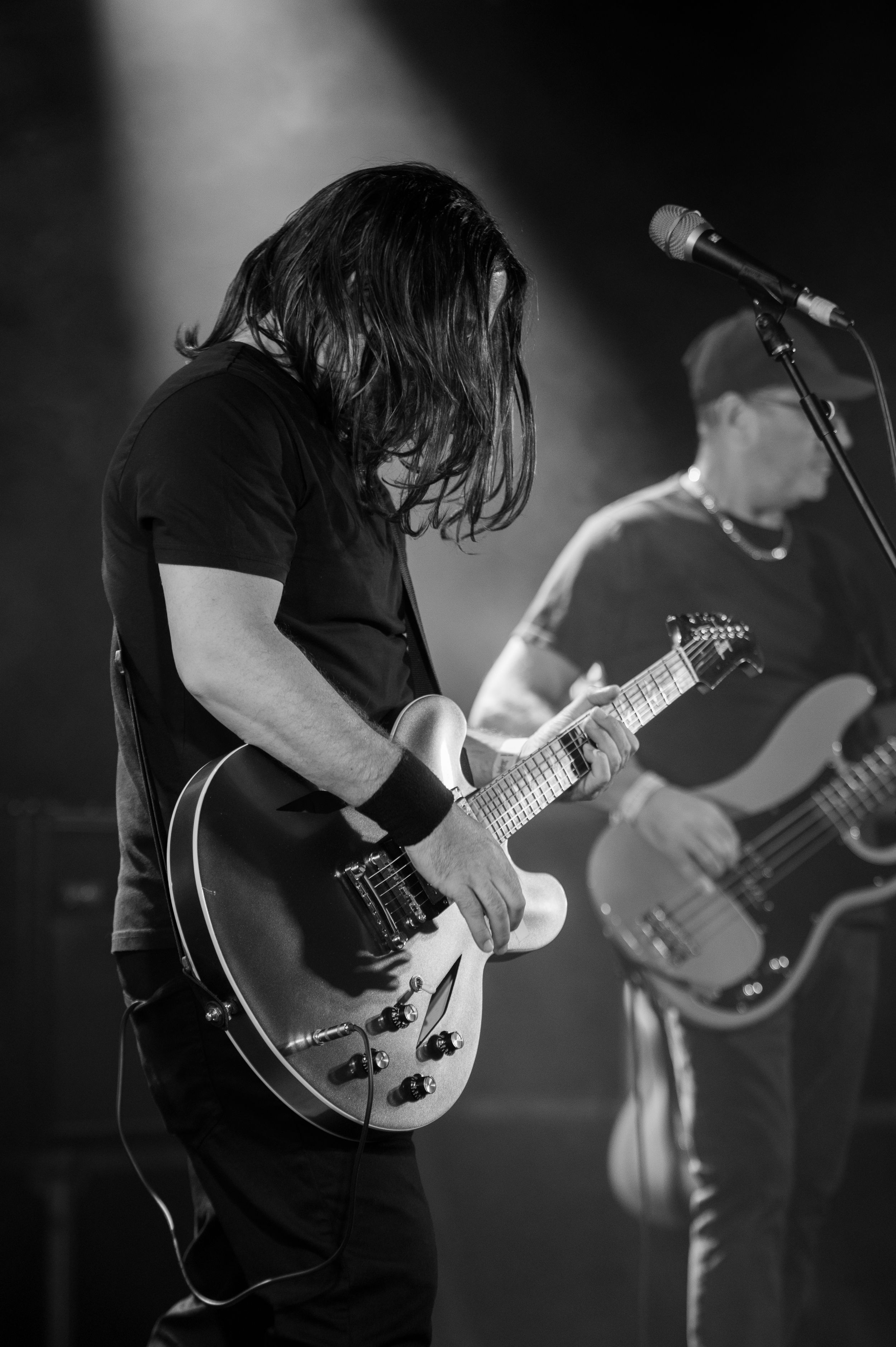 Black and white photo sequence showing close-up shots of a guitarist performing with intense focus on stage.