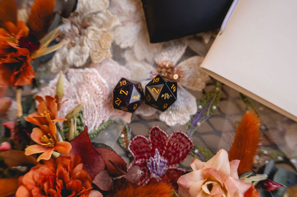 Colorful autumn-themed tabletop display with orange flowers, dice, and decorative elements in warm fall colors.