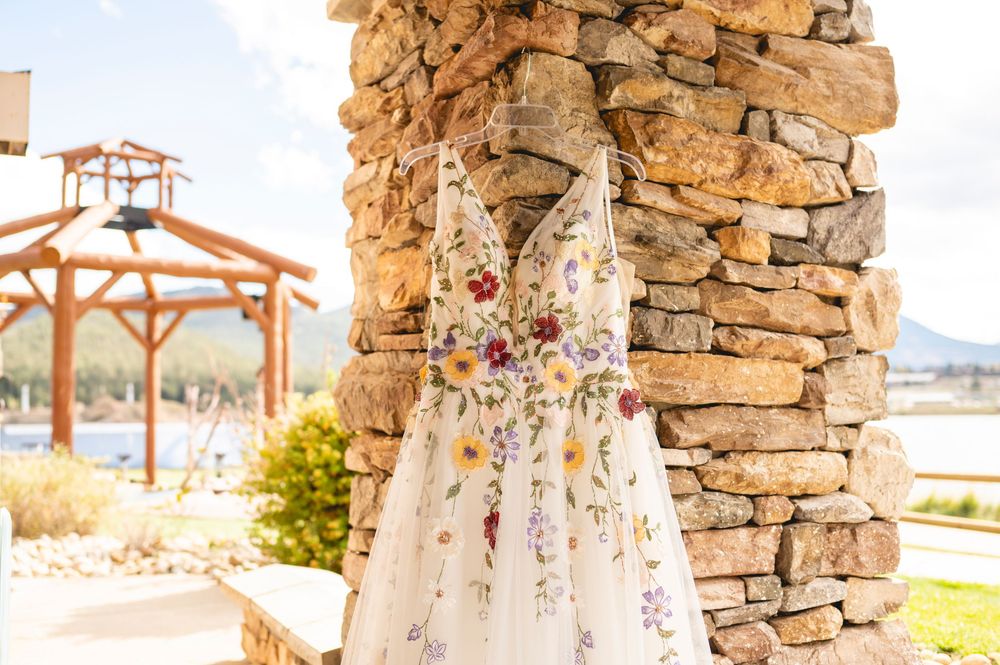 Stone pillars and wooden pergolas create a romantic outdoor wedding ceremony setting at sunset.