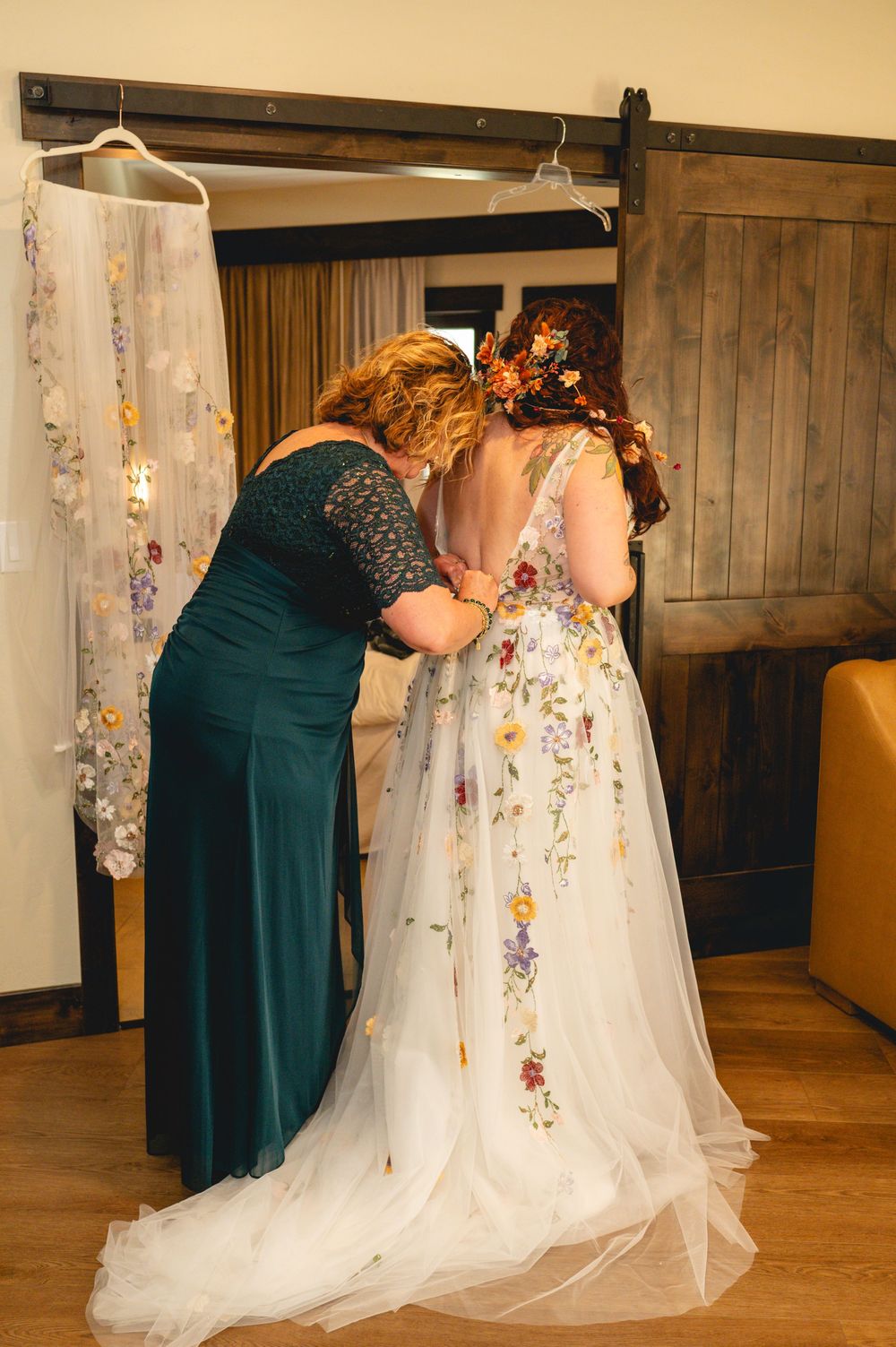 Sequence of photos showing a bridesmaid in teal dress helping adjust a bride's floral embroidered wedding gown train.