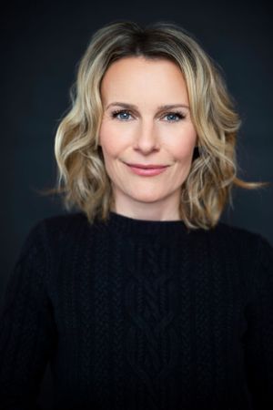 headshot photograph of a beautiful woman with blonde hair and blue eyes looking directly into the lens