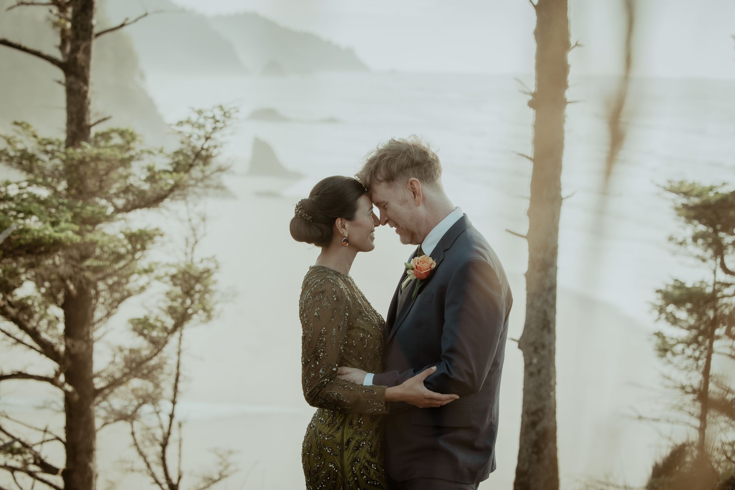 An intimate moment between a couple surrounded by misty forest trees.