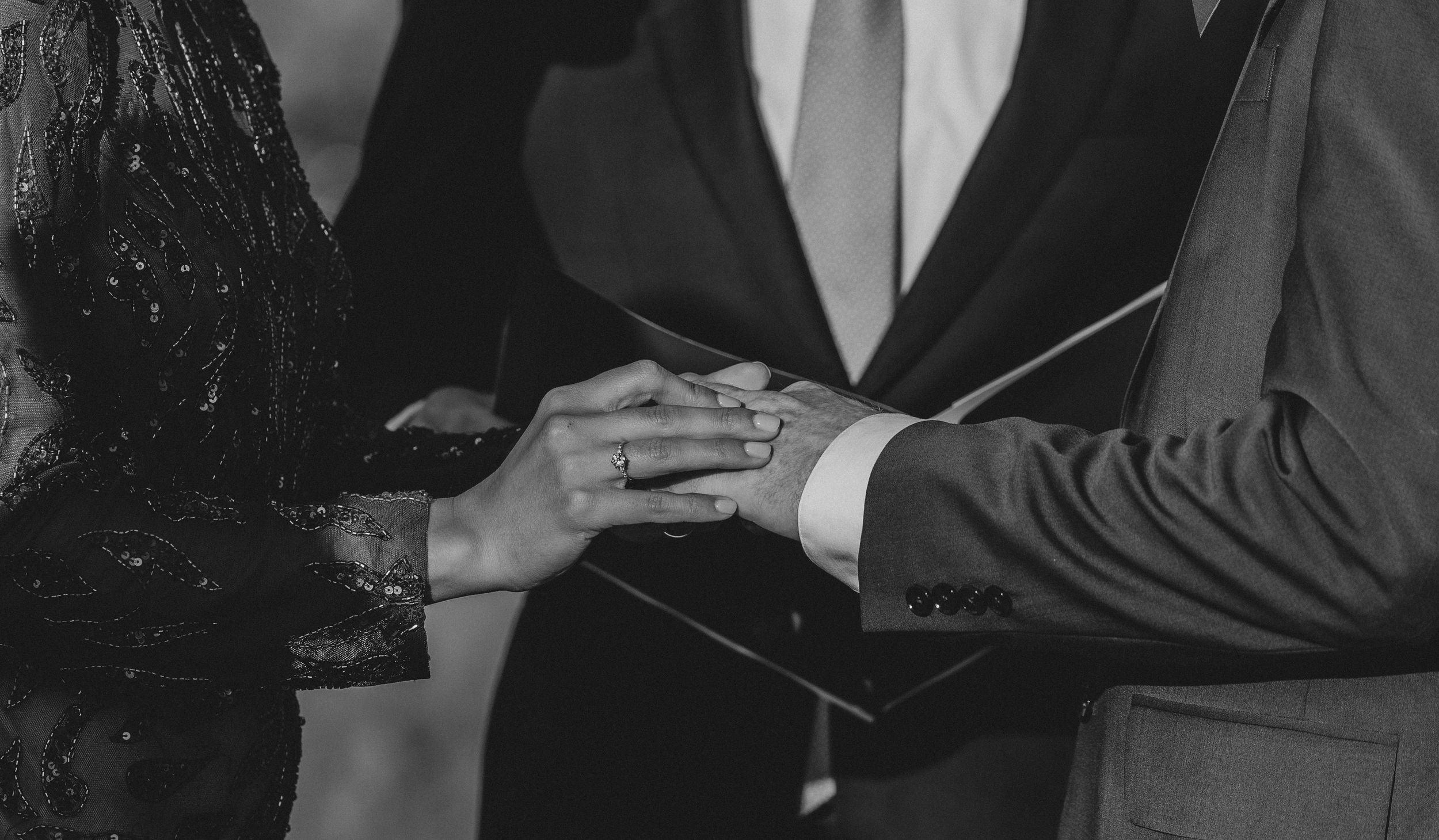 A black and white intimate portrait of a couple in formal attire.