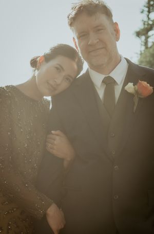 Intimate sunlit portrait session against a bright sky with soft golden light filtering through.