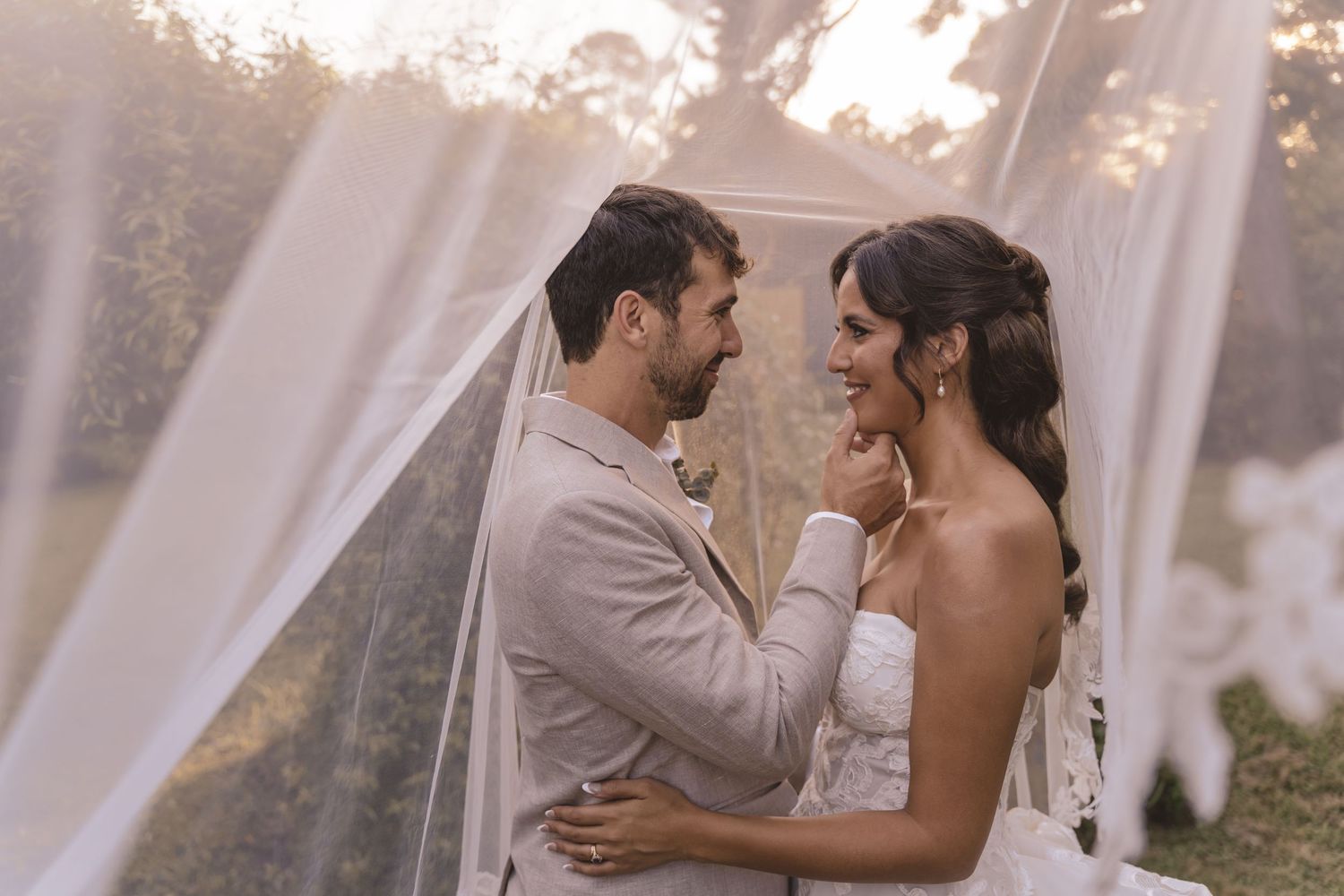 Bride and groom embracing under sheer fabric at Farmhouse Siloam in Mount Airy, NC
