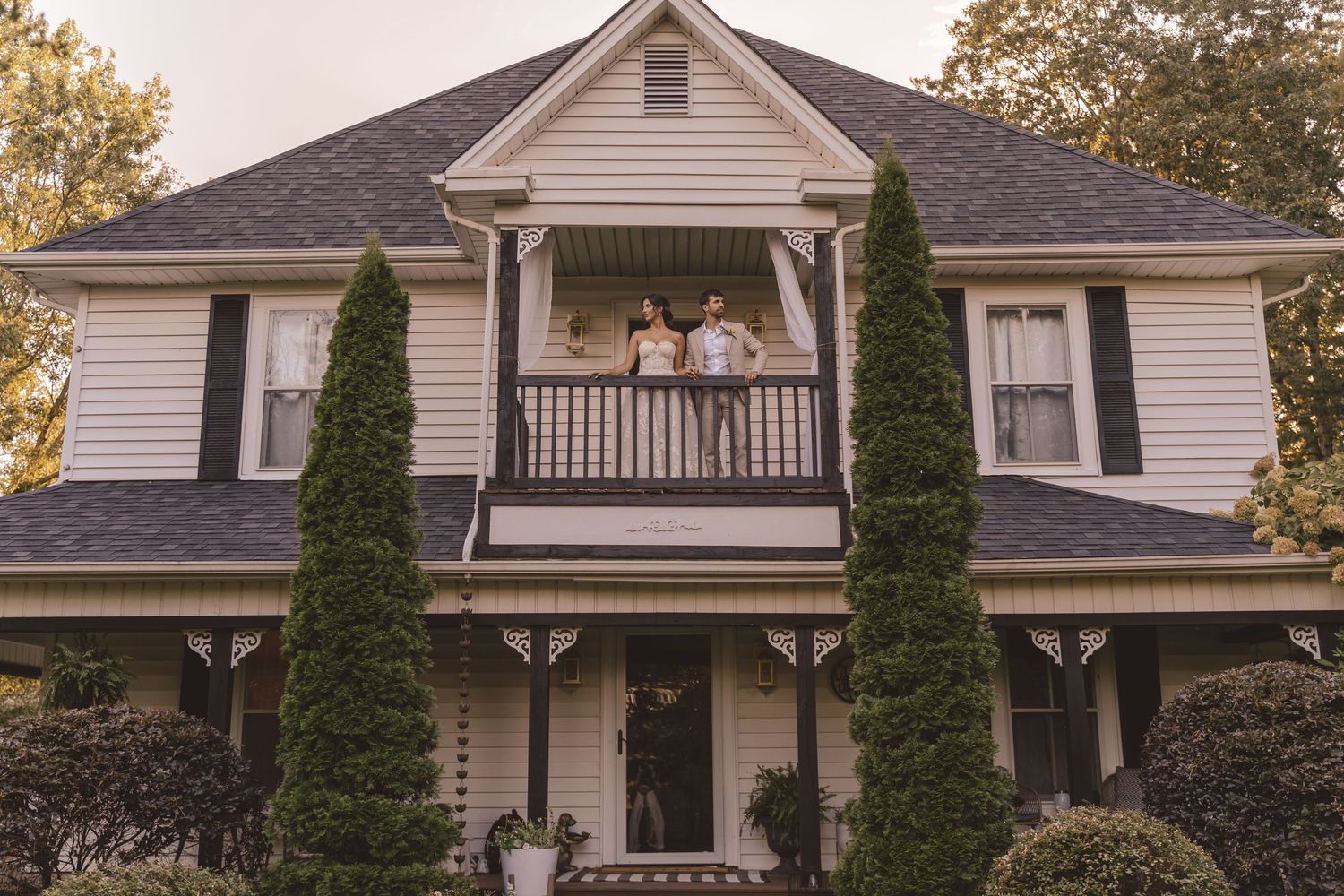 Bride and groom standing on the balcony at Farmhouse Siloam in Mount Airy, NC