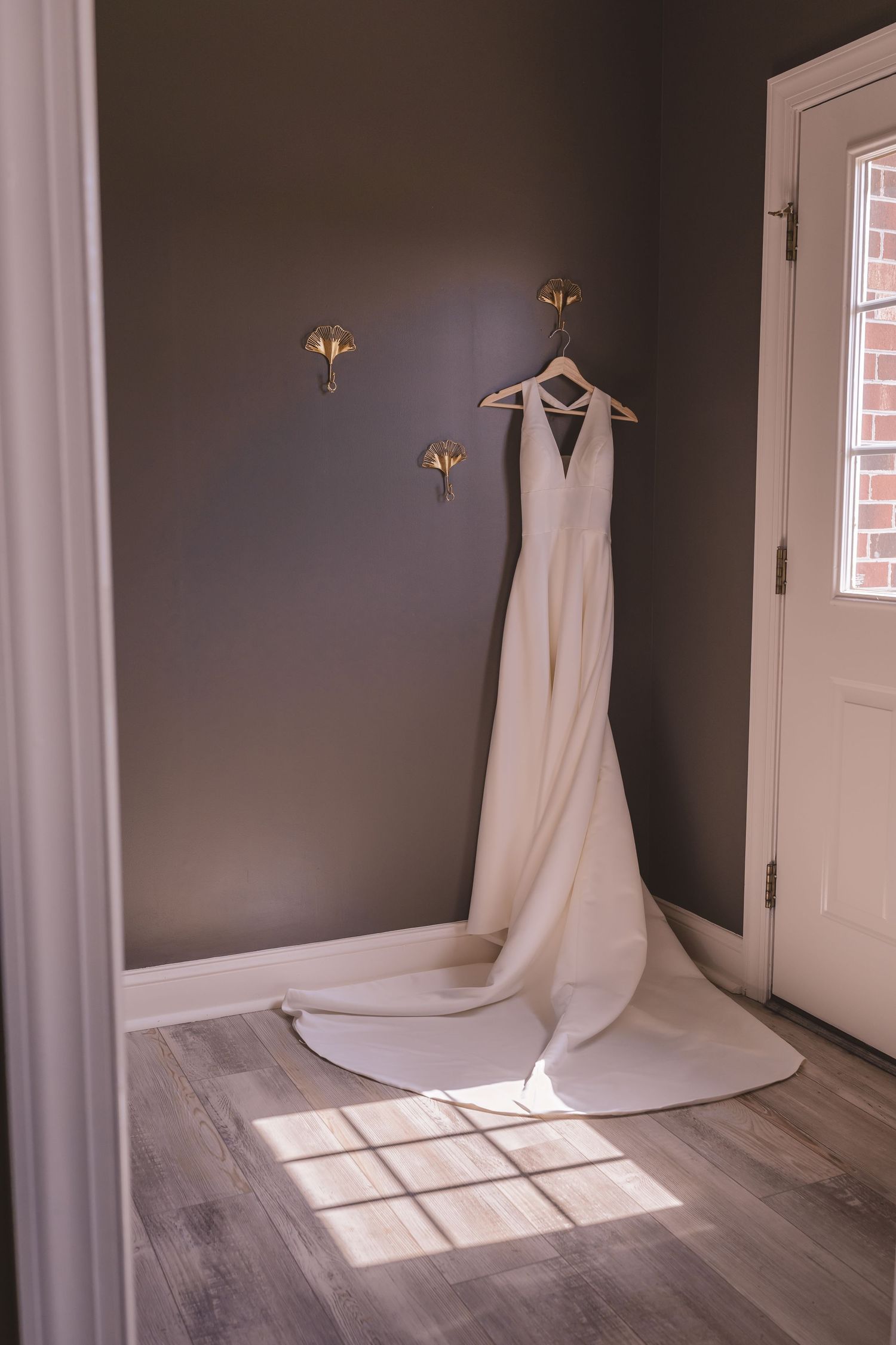 Wedding dress and wedding rings hanging from the wall at Willow and Stone Events in Mocksville, NC