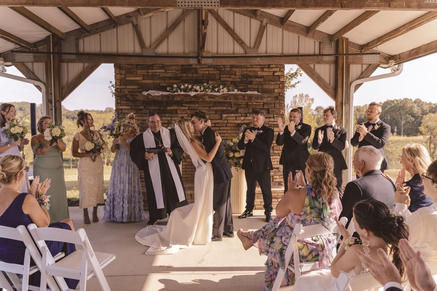 Newlyweds sharing their first kiss at the ceremony at Willow and Stone Events in Mocksville, NC