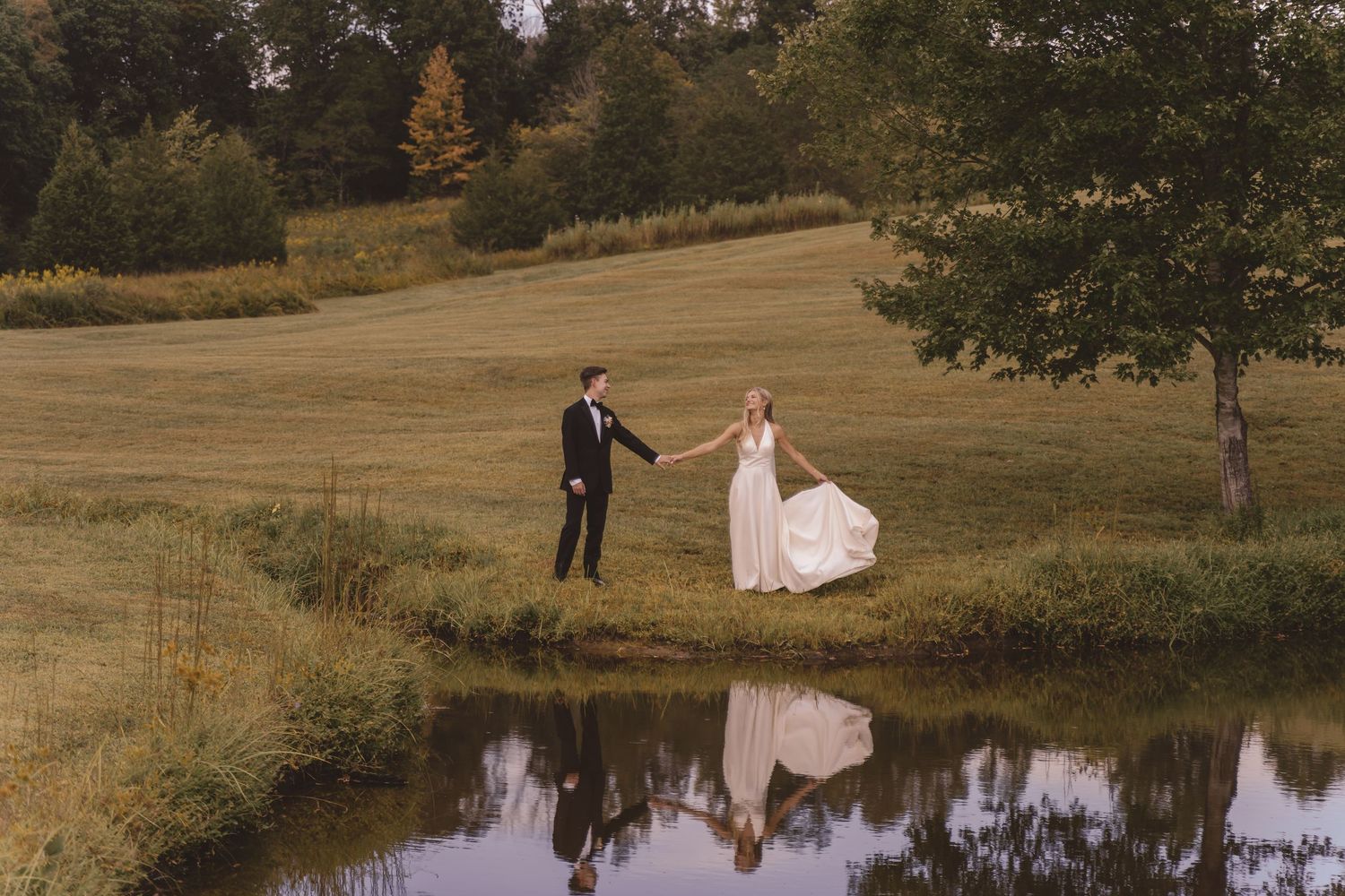 Bride and groom sharing a moment by the pond at Willow and Stone Events in Mocksville, NC