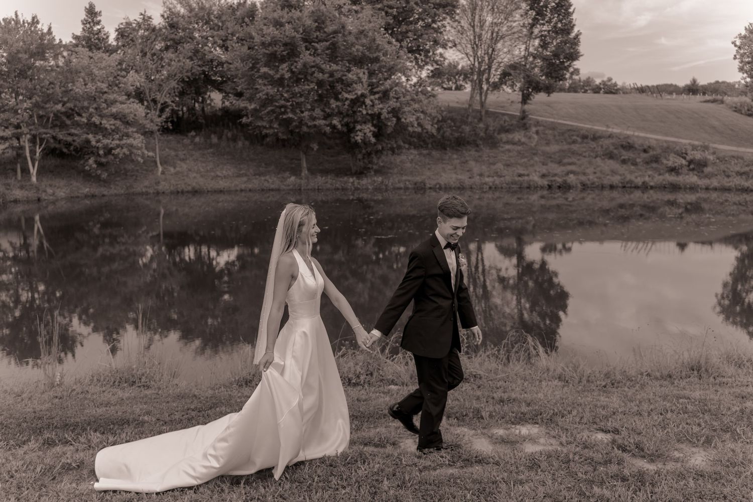 Bride and groom walking by the pond at Willow and Stone Events in Mocksville, NC