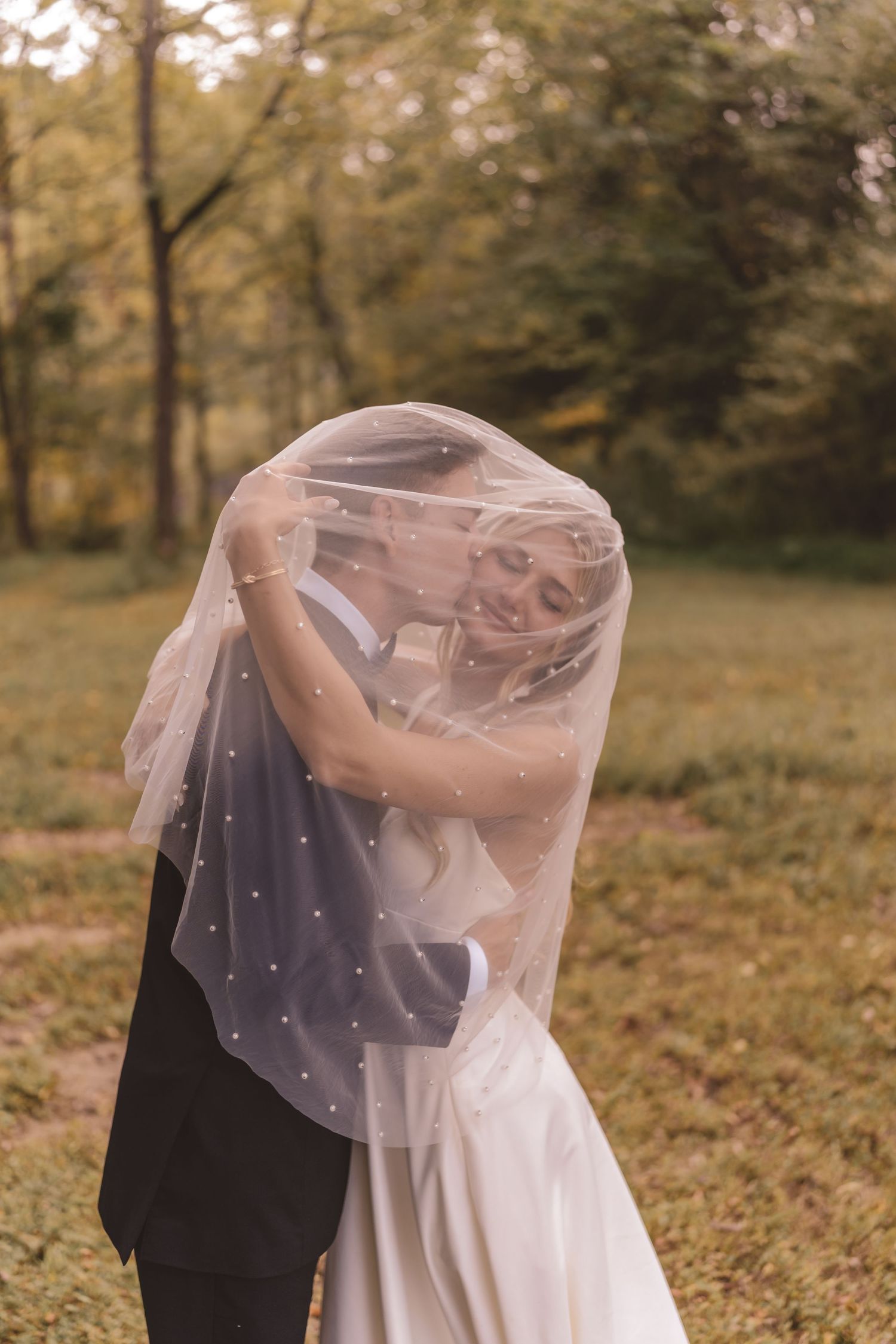 Bride and groom embracing under the veil at Willow and Stone Events in Mocksville, NC