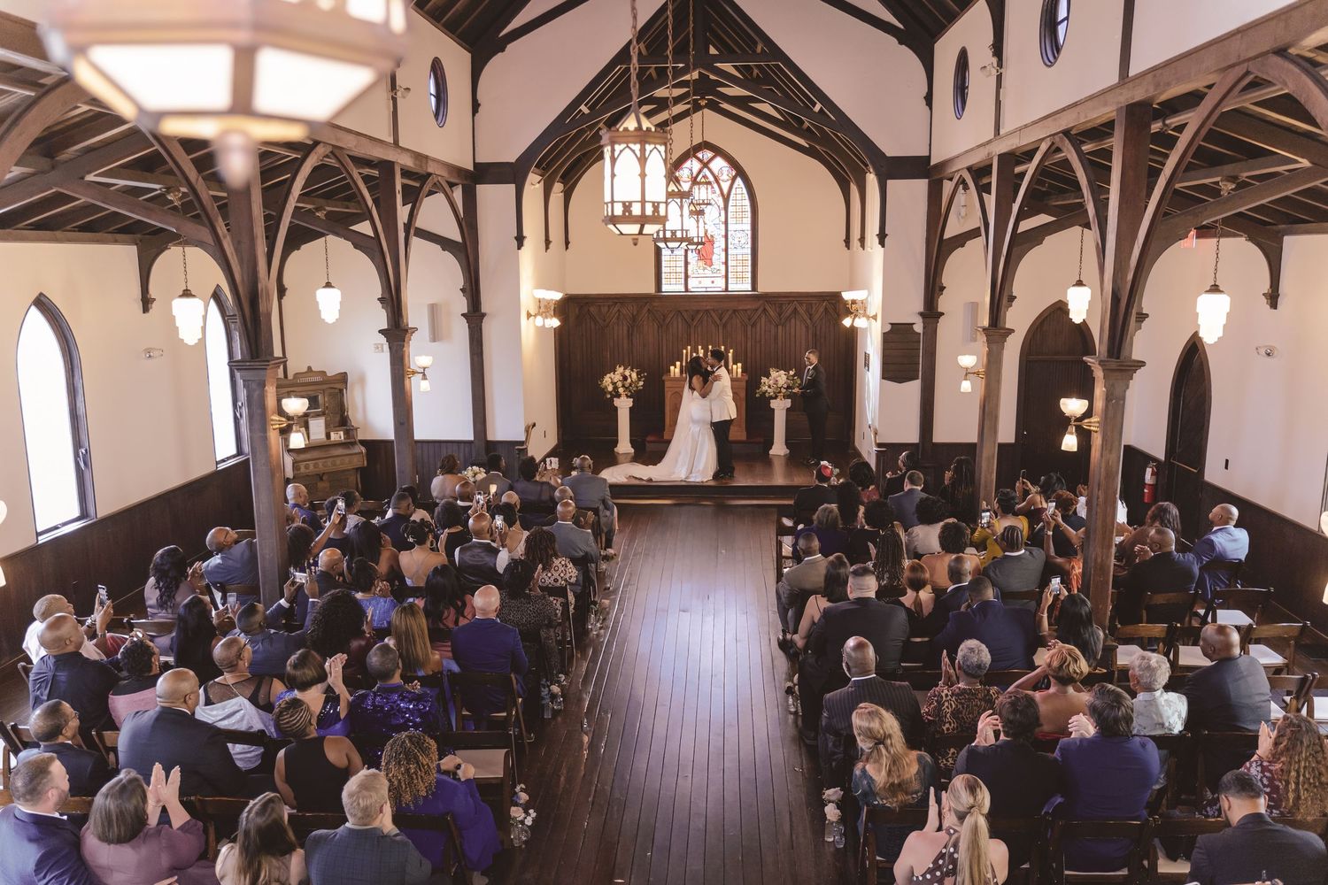 Newlyweds sharing a first kiss at the wedding ceremony at All Saints Chapel in Raleigh, NC