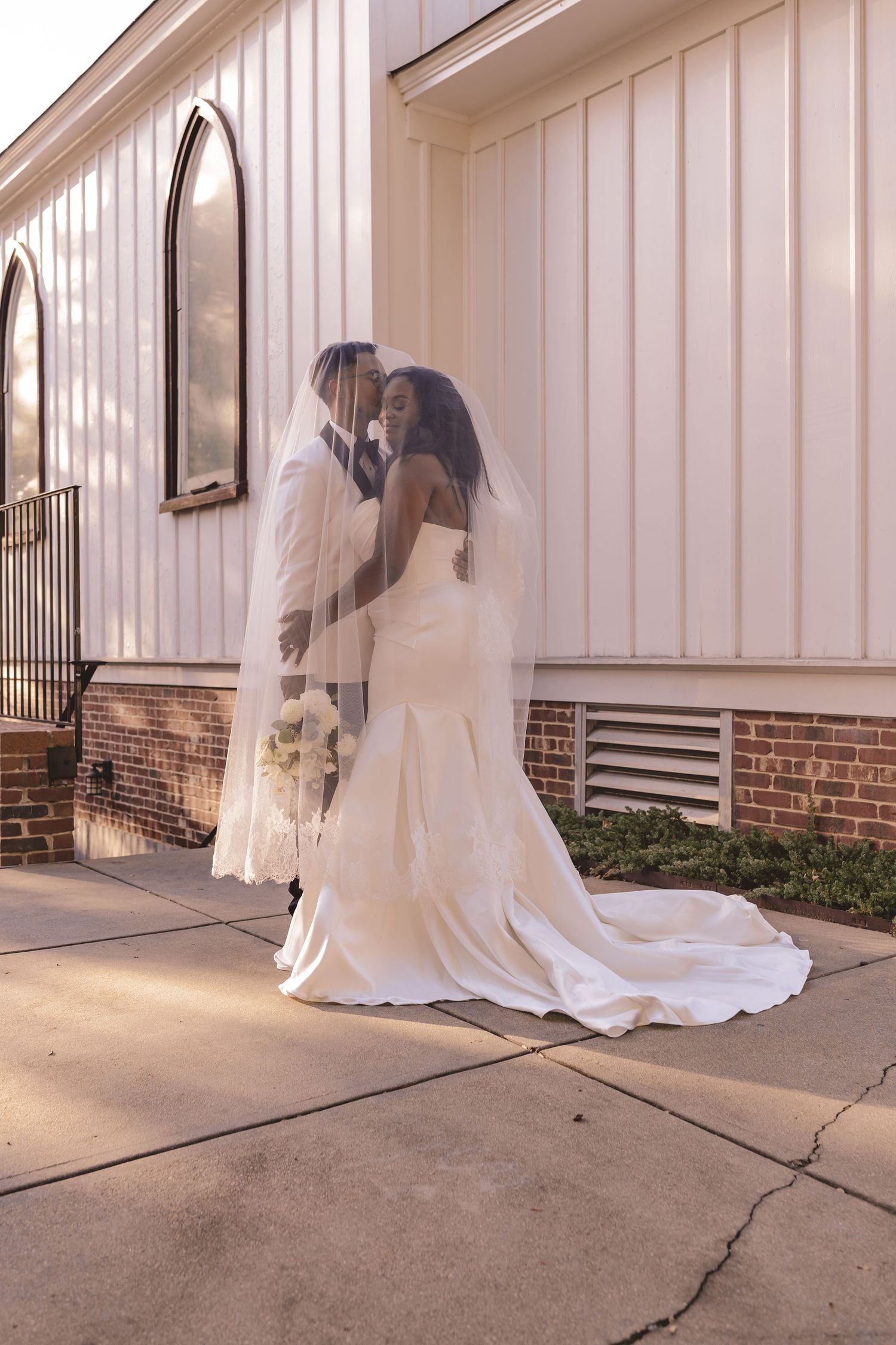 Bride and groom sharing a moment under the veil at All Saints Chapel in Raleigh, NC