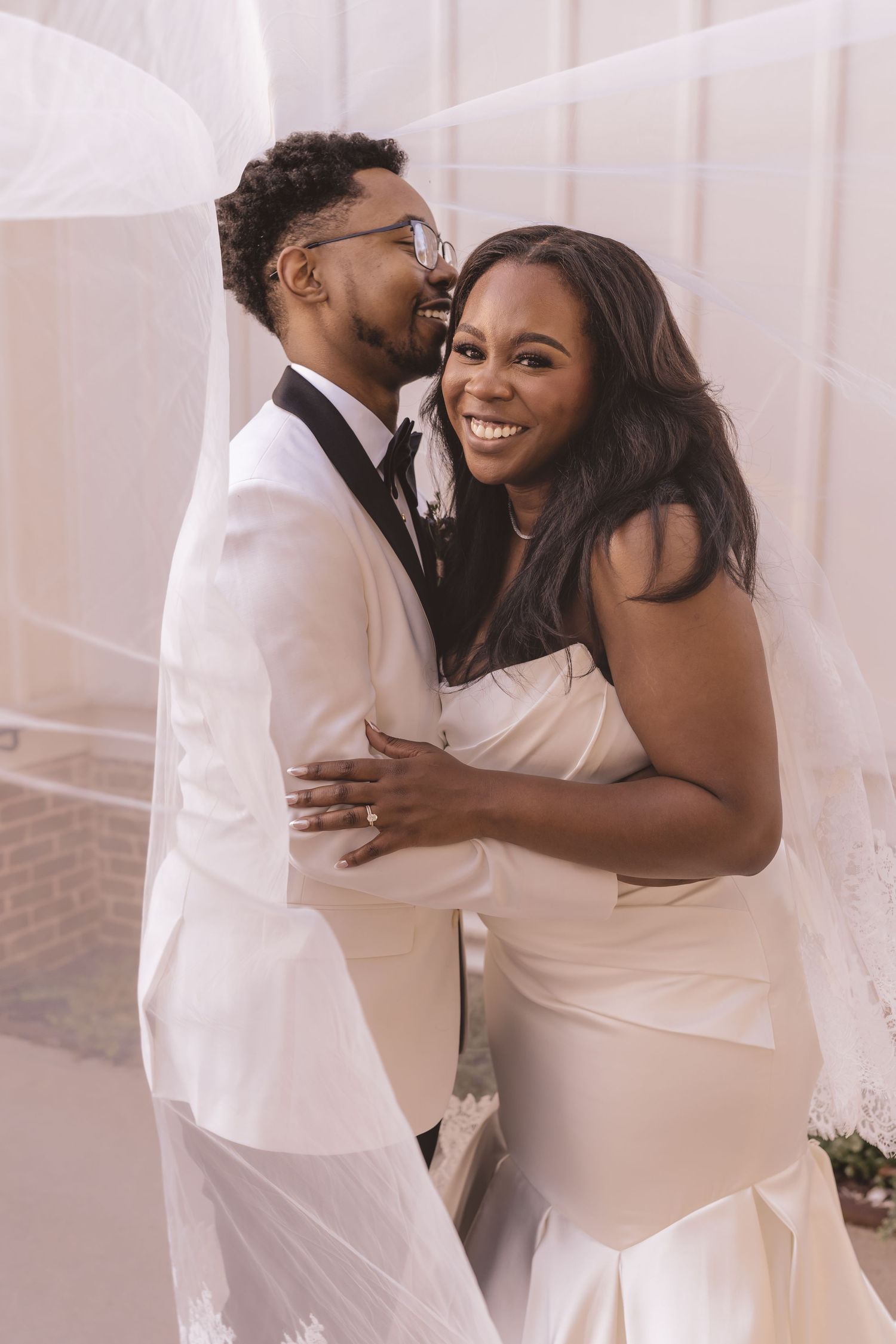 Bride and groom embracing under the veil at All Saints Chapel in Raleigh, NC