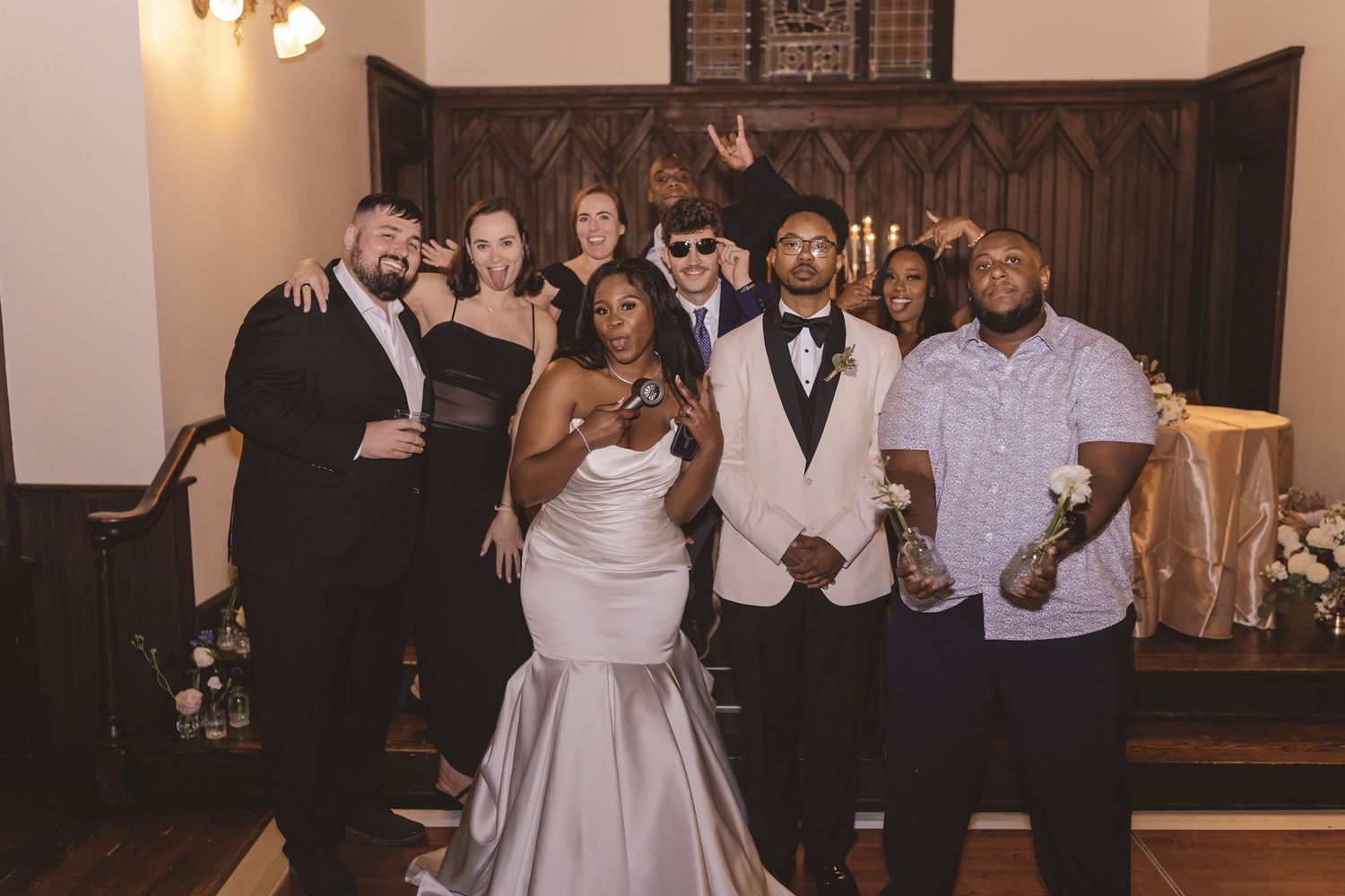 Bride and groom hanging with their friends at the wedding reception at All Saints Chapel in Raleigh, NC