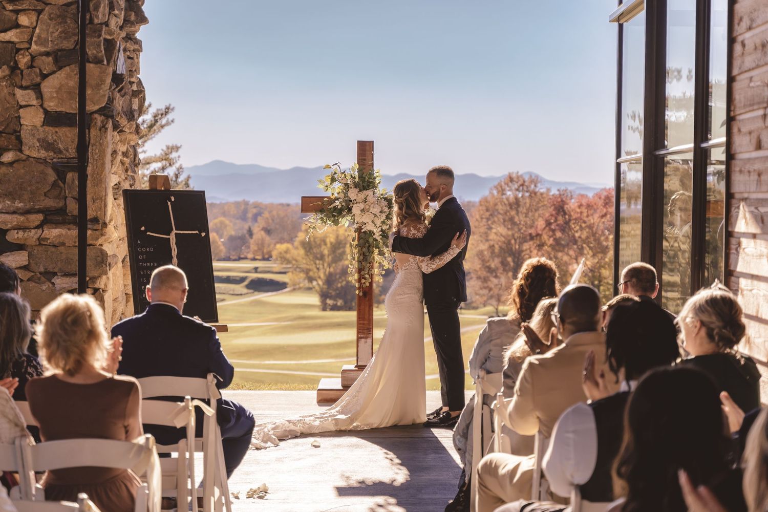 Bride and groom sharing their first kiss during wedding ceremony at Omni Grove Park Inn in Asheville, NC