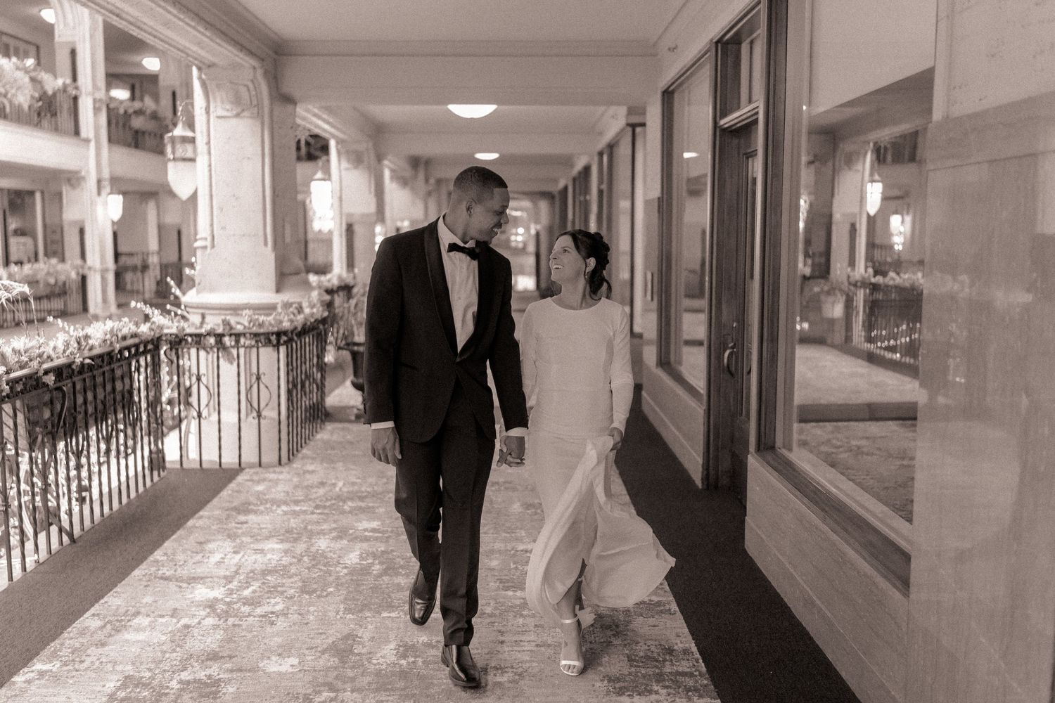 Bride and groom walking along the terrace at Grove Arcade in Asheville, NC