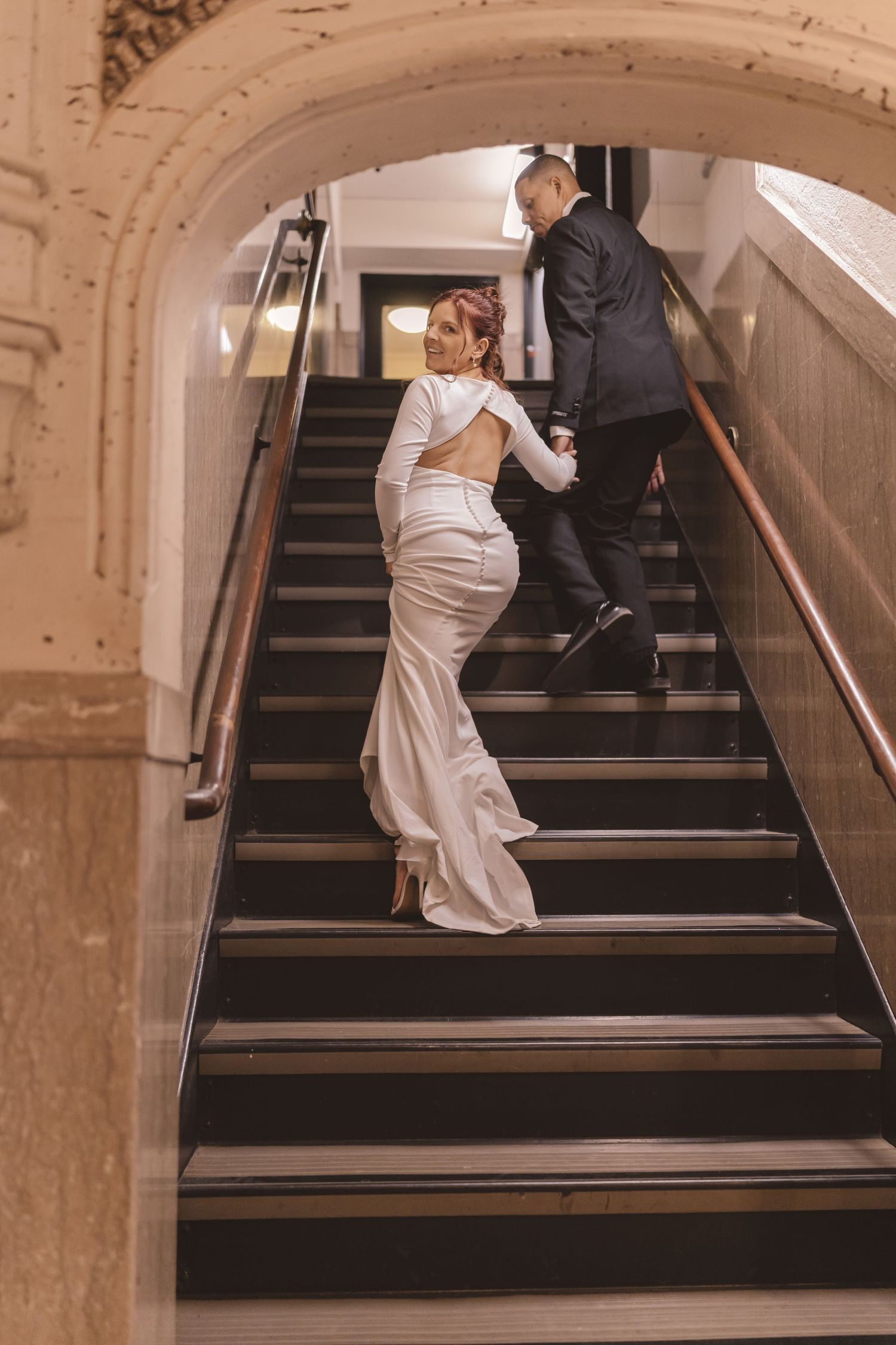 Bride and groom walking up the stairs inside the Grove Arcade in Asheville, NC