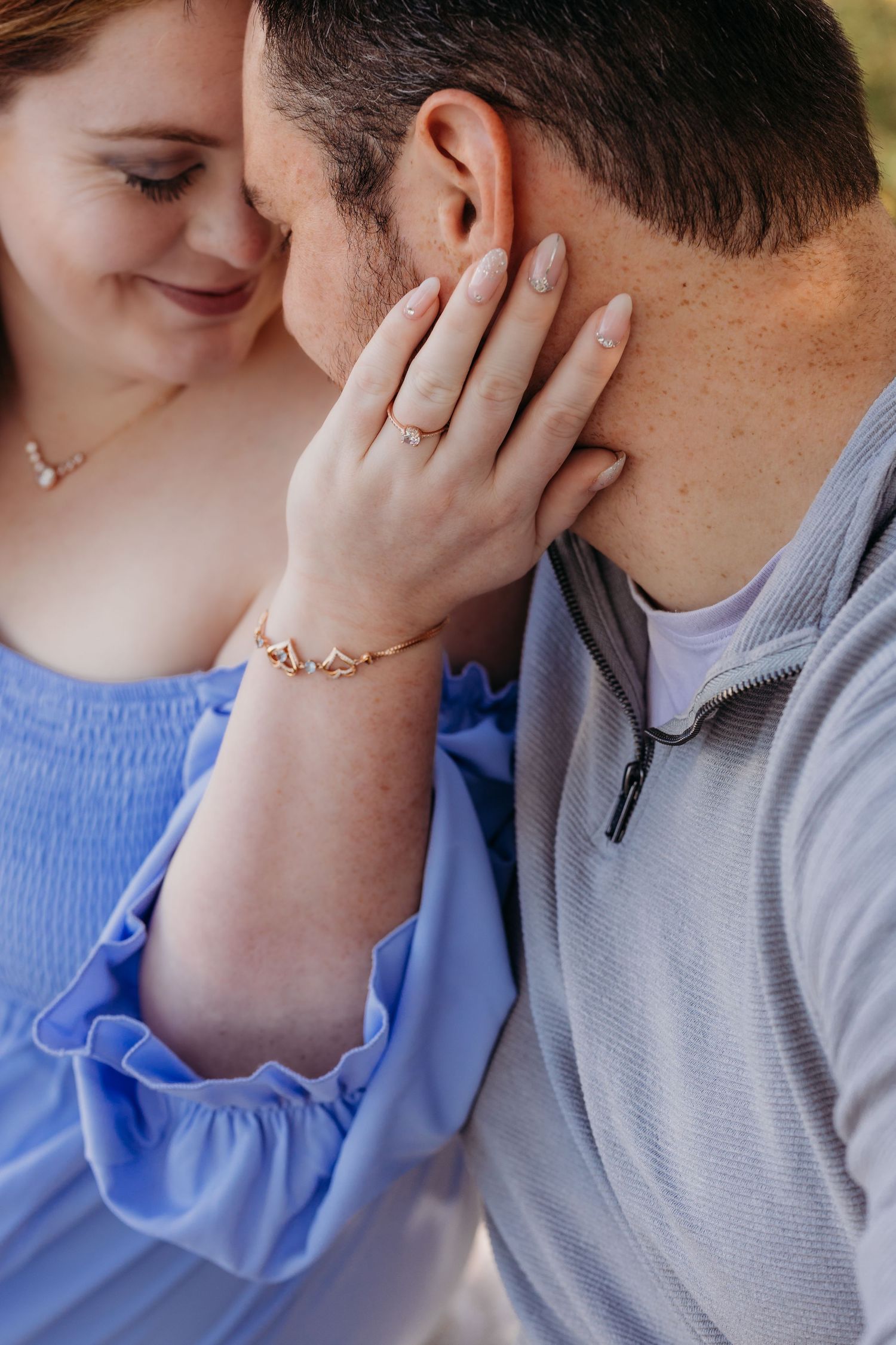 Close-up of gentle touch and intimacy between couple during outdoor photoshoot.