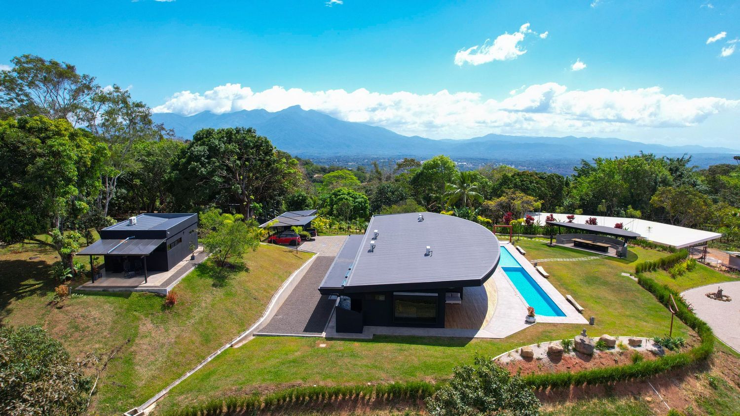 Outdoor pool area with wooden deck, lounge space, and stunning natural surroundings
