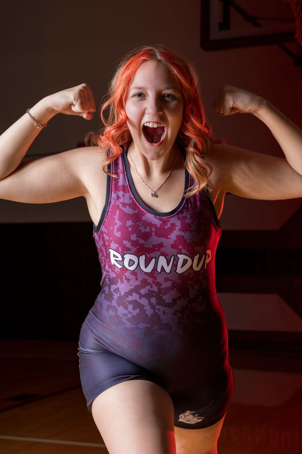 A female wrestler poses confidently in gear, showcasing strength, determination, and focus in a powerful, dynamic sports portrait.