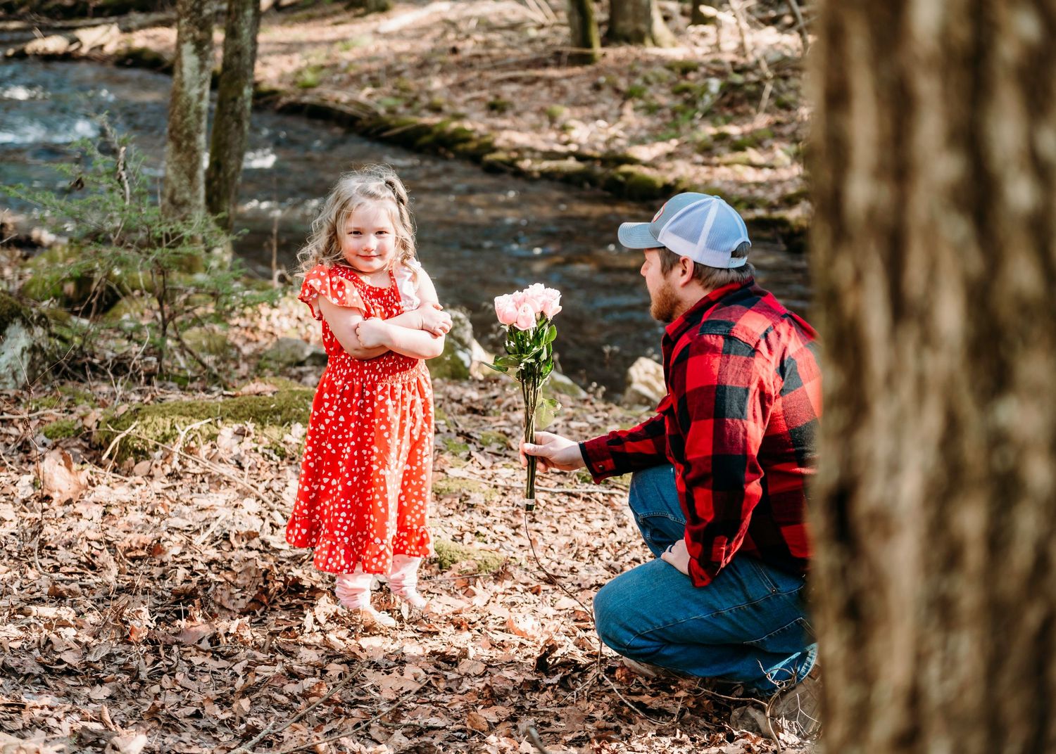 A sweet exchange by a forest stream with pink flowers and classic buffalo plaid.
