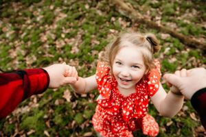 A candid moment of pure joy captured during playtime in a wooded area.