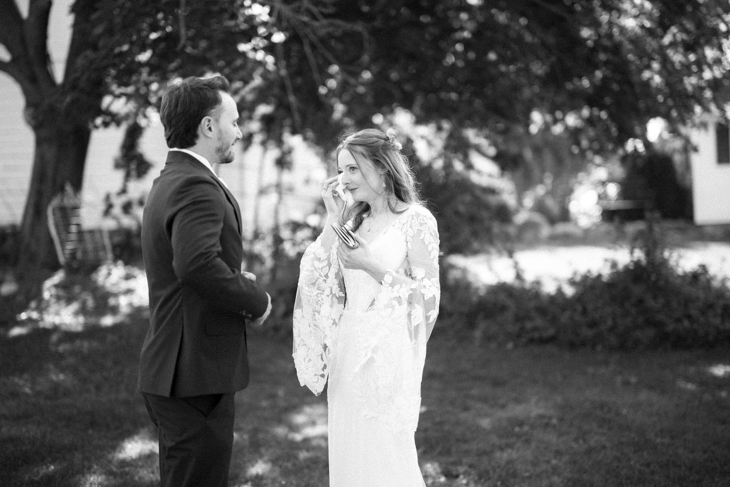 A couple shares a joyful moment together outdoors during a wedding celebration.