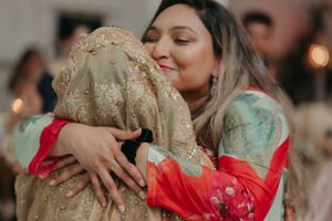 Emotional embrace captured during wedding celebration in vibrant traditional attire.