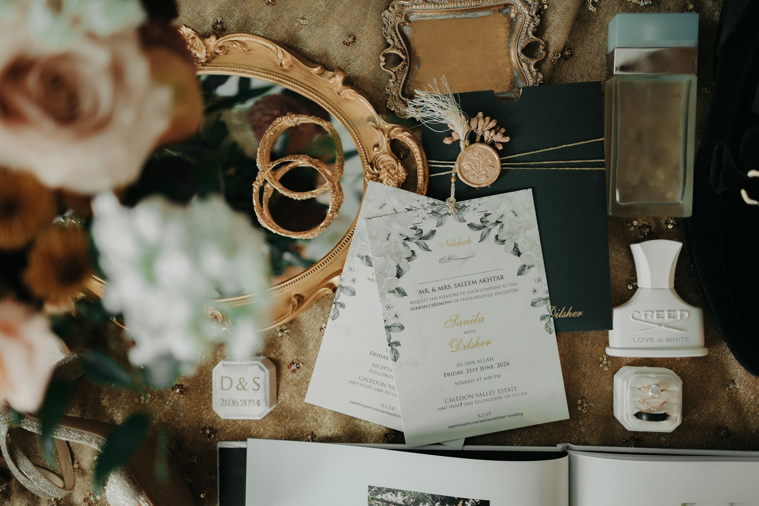 Wedding details including invitation and decor items arranged on a rustic surface.