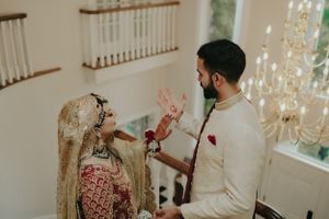 A couple in traditional wedding attire shares an intimate moment during a ceremony.