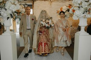 A traditional South Asian wedding ceremony with floral decorations and elegant white pillars.