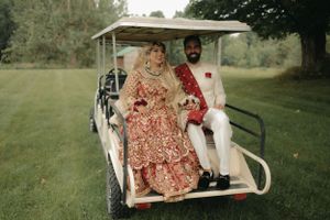 Newlyweds ride together in a golf cart during their wedding celebration.