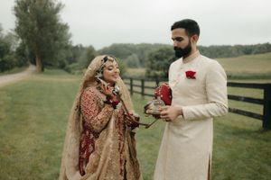 Couple in traditional wedding attire shares a moment outdoors during their celebration.