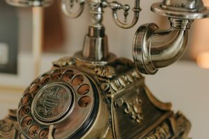 Close-up of an ornate vintage brass telephone with decorative details.
