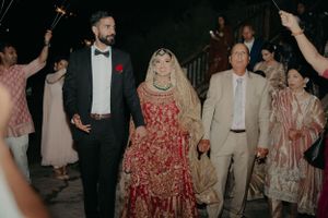 A wedding exit procession with sparklers as the couple walks through in formal attire.