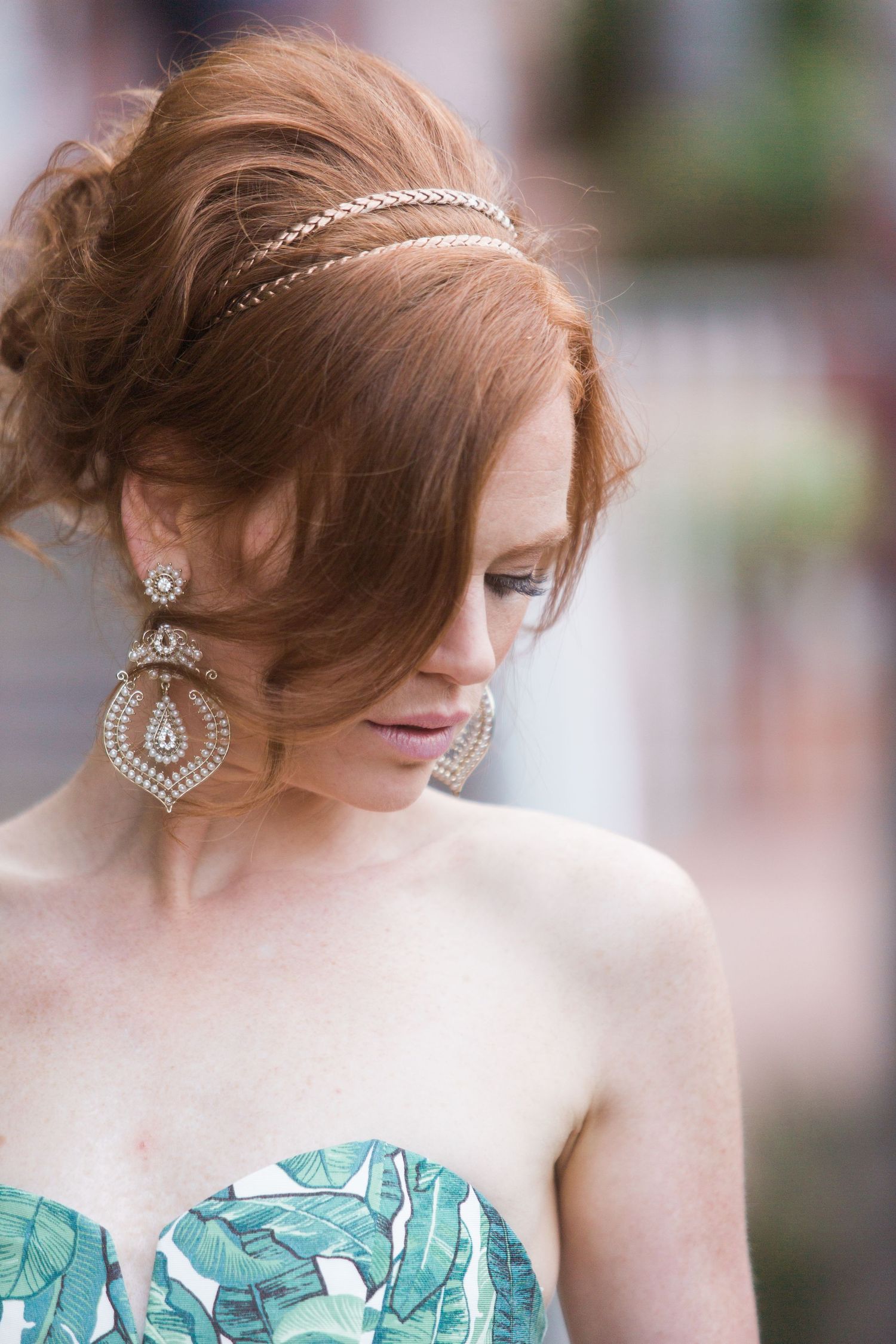 Close up of elegant hairstyle with crystal headpiece and chandelier earrings.