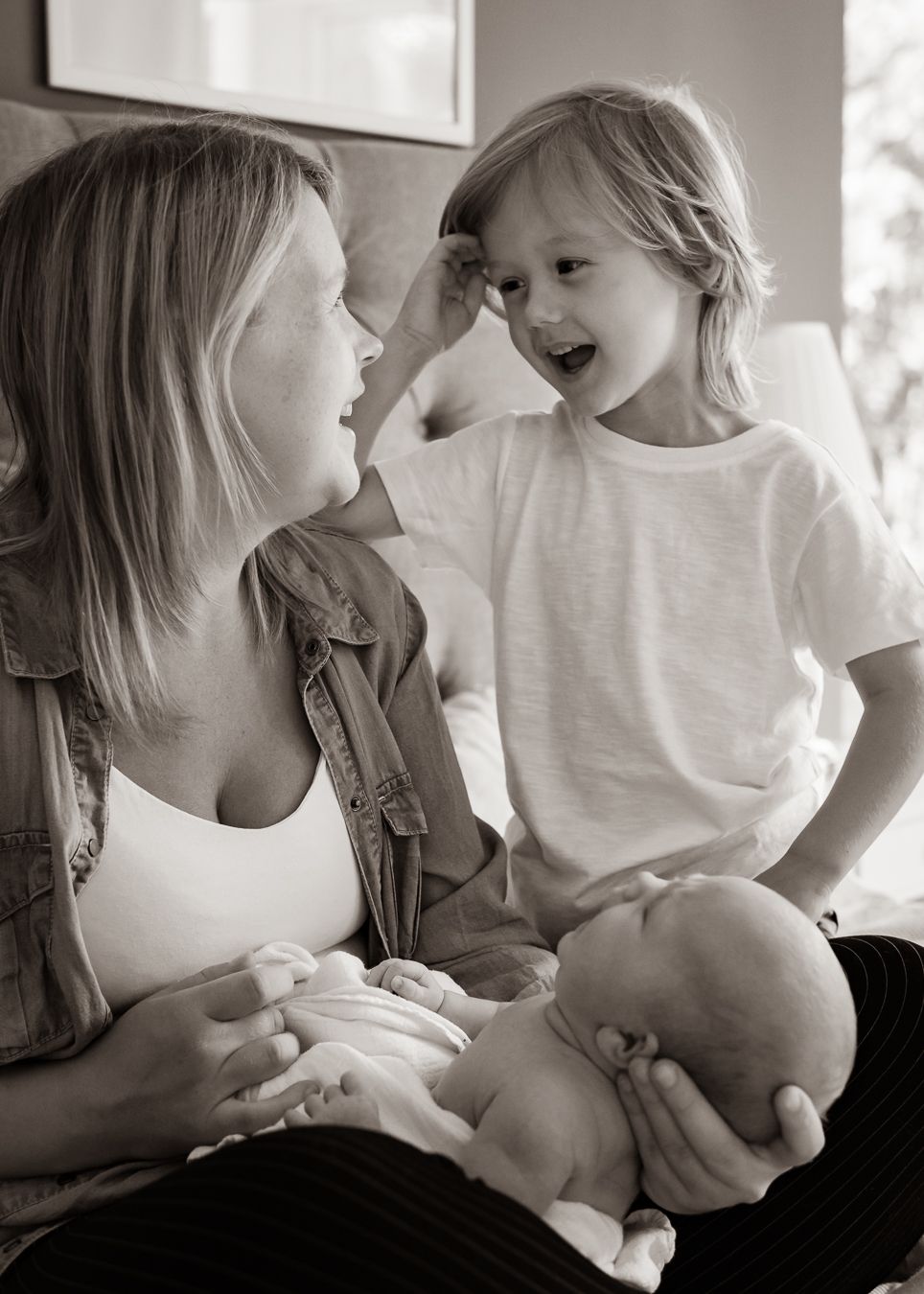 Joyful family moment with a newborn baby on a couch at home.