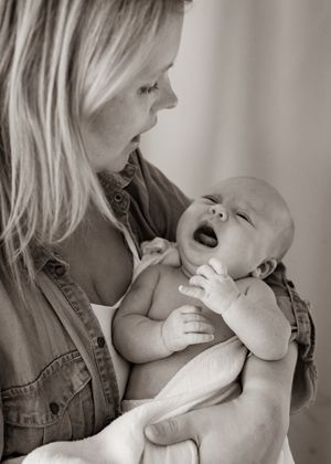 Black and white portrait of tender interaction with a laughing infant.
