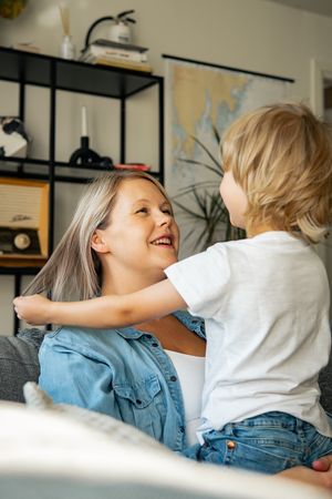 Joyful playtime moment on a cozy grey sofa at home.