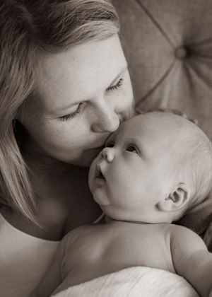 Tender moment between parent and infant captured in black and white.