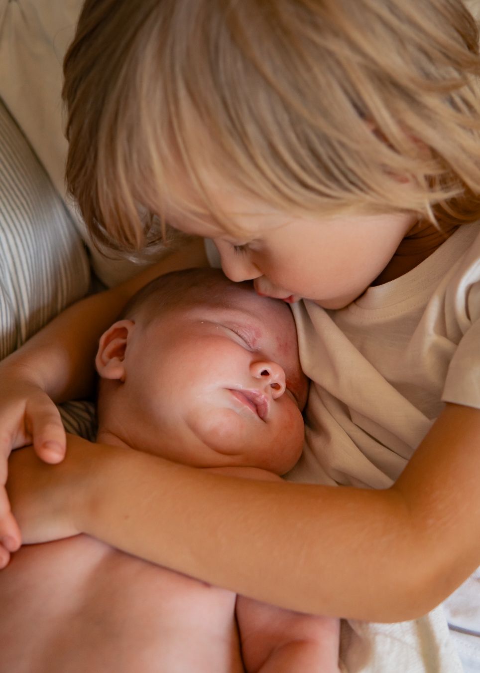 Gentle moment of two siblings sharing a tender embrace.