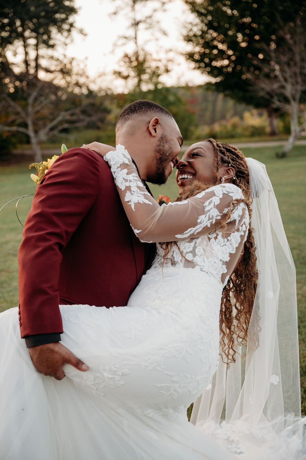 A romantic sunset wedding photo in a garden setting.