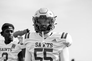 Saints football player in white uniform poses during game day.