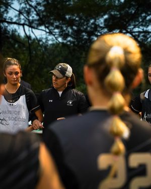 Coach giving instructions to team during soccer practice.