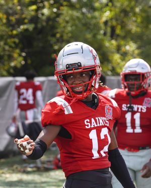 Saints football player in red jersey number 12 celebrates during a game.