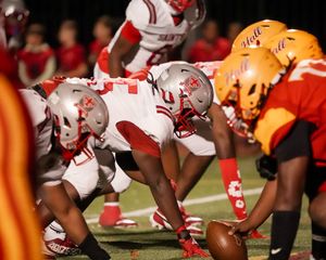 Football players line up at scrimmage during intense game action.