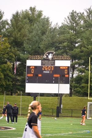 John Carroll scoreboard showing 0-0 score during sports match.