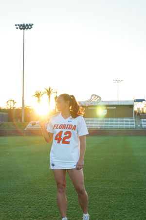 Florida Gators player wearing jersey #42 poses on athletic field at sunset.