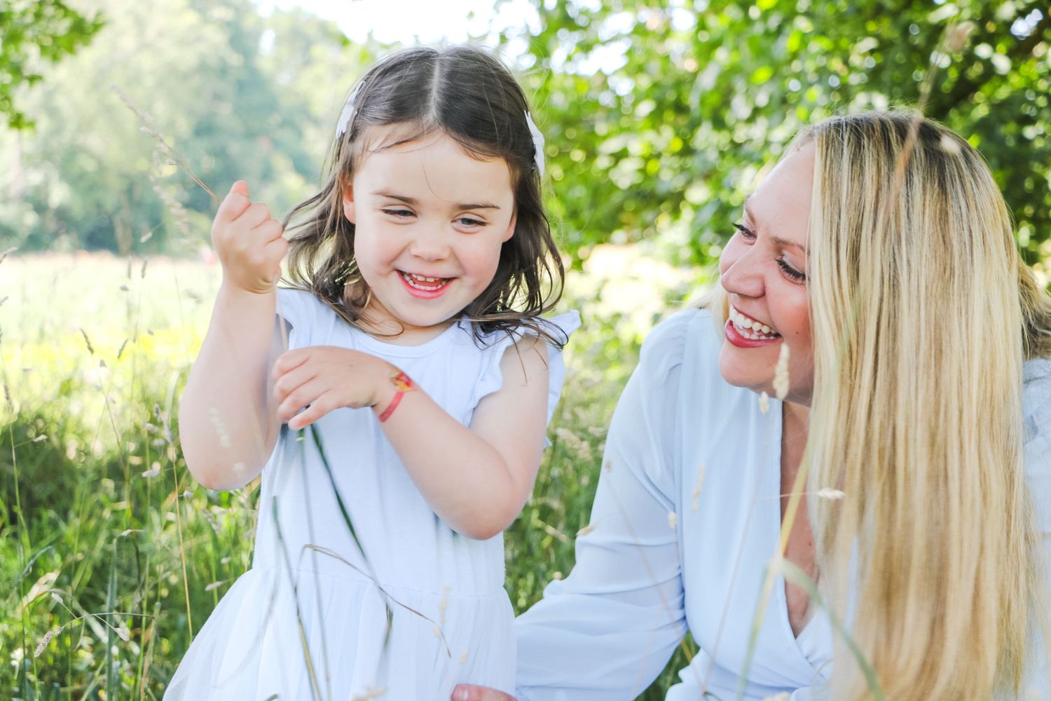 A joyful outdoor scene with shared laughter in a sunlit meadow.
